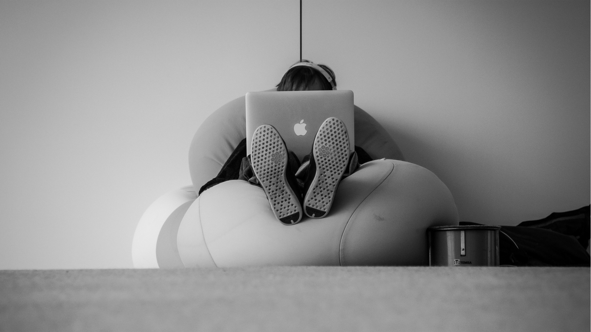 Man sitting alone with computer covering his face