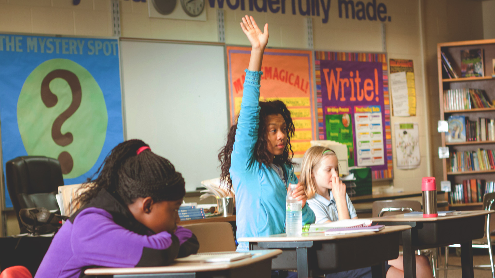 Girl raising hand in classroom