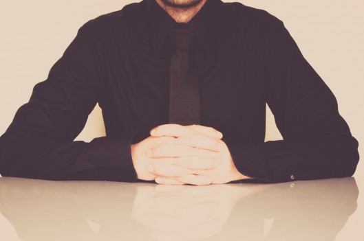 Man sitting with hands folded