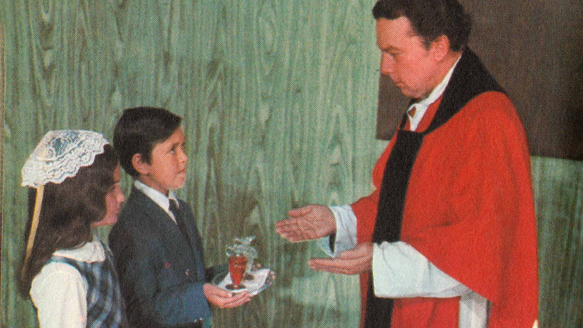 Priest giving children communion | Growing Up As a Reluctant Catholic