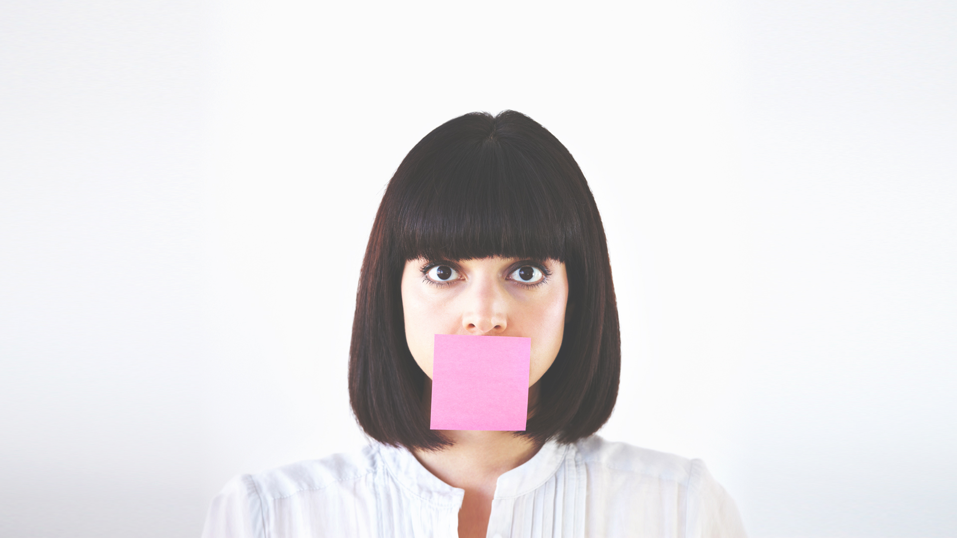 Woman with post-it covering her mouth